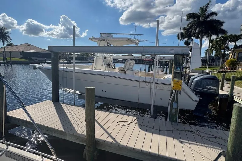  Yacht Photos Pics 2014 Stamas 317 Tarpon boat docked by waterfront, under clear sky with palm trees.