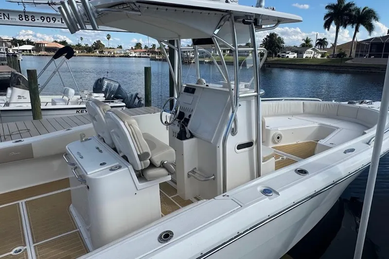  Yacht Photos Pics 2014 Stamas 317 Tarpon boat docked by waterfront homes, featuring spacious seating and helm.