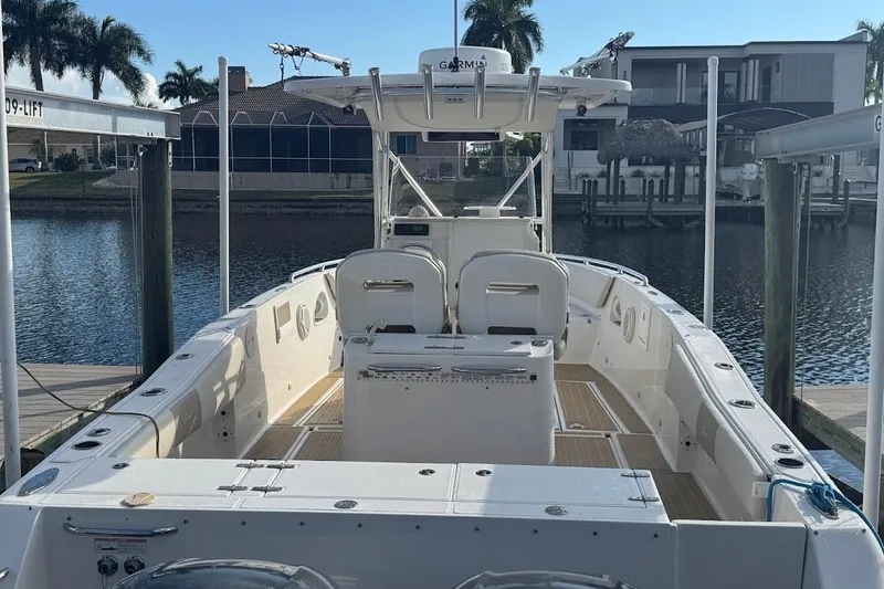 Yacht Photos Pics 2014 Stamas 317 Tarpon boat docked by waterfront homes, featuring spacious deck and seating.