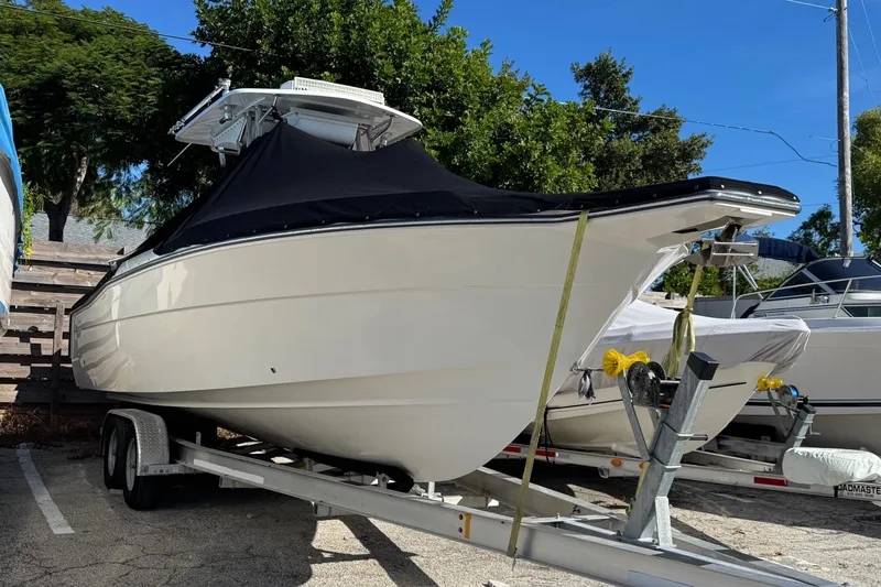  Yacht Photos Pics 2014 Stamas 317 Tarpon boat on trailer, covered, parked outdoors.