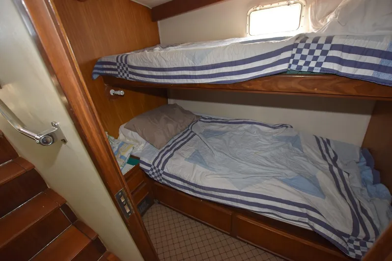 The Office Yacht Photos Pics 1987 Hatteras SportFish cabin with bunk beds and nautical-themed bedding.