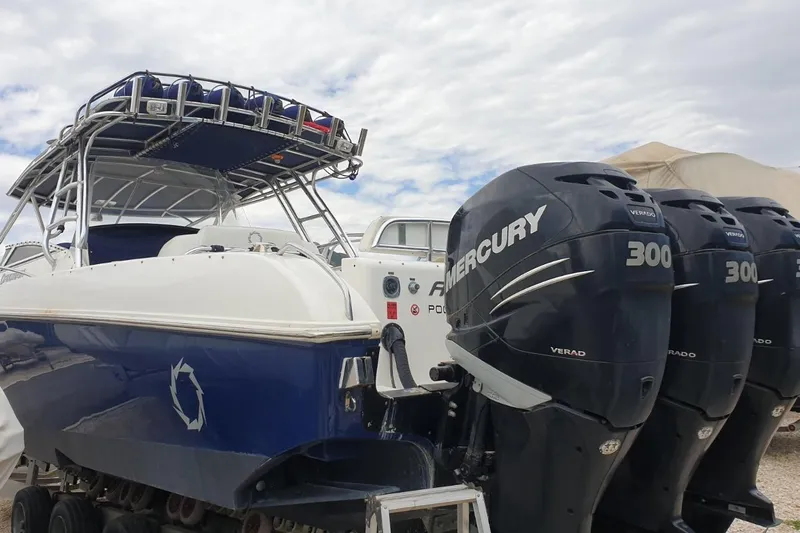 &Beta;&alpha;&rho;&alpha;&mu;&pi;έ&sigma;&sigma;&alpha; Yacht Photos Pics 2009 Fountain 38 LX boat with triple Mercury 300 Verado engines, docked under cloudy sky.