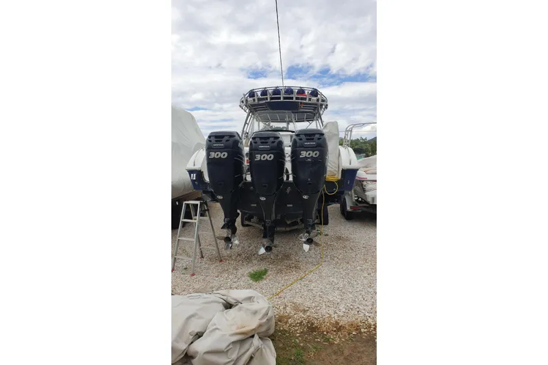 &Beta;&alpha;&rho;&alpha;&mu;&pi;έ&sigma;&sigma;&alpha; Yacht Photos Pics 2009 Fountain 38 LX boat with triple 300 horsepower engines, parked on gravel.