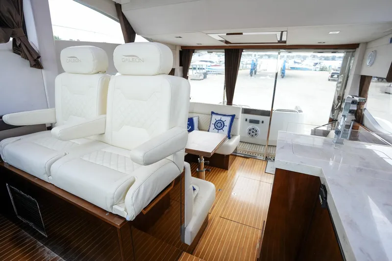  Yacht Photos Pics Luxurious interior of 2017 Galeon 43 SKY yacht with white leather seating and wooden flooring.