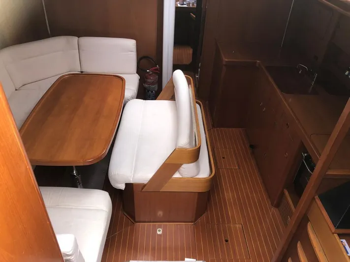 "acamar Iii" Yacht Photos Pics Interior of 1992 Grand Soleil 45 German Frers yacht with wooden dining area and white seating.