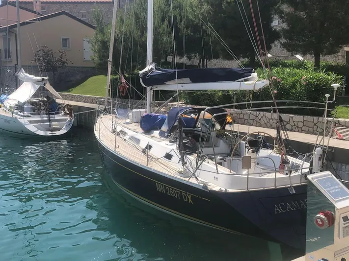 "acamar Iii" Yacht Photos Pics Grand Soleil 45 German Frers 1992 sailboat docked in a serene marina setting.