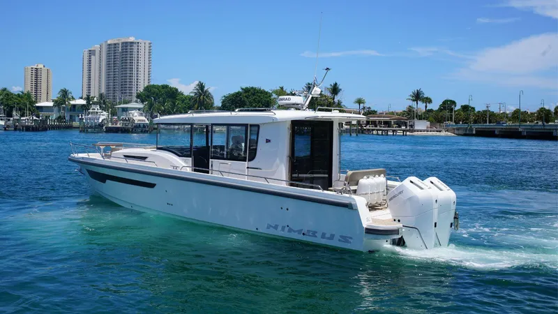 In-stock 2024 Nimbus C11 #082 Yacht Photos Pics 2024 Nimbus Commuter 11 #082 boat cruising on a sunny day near a city waterfront.