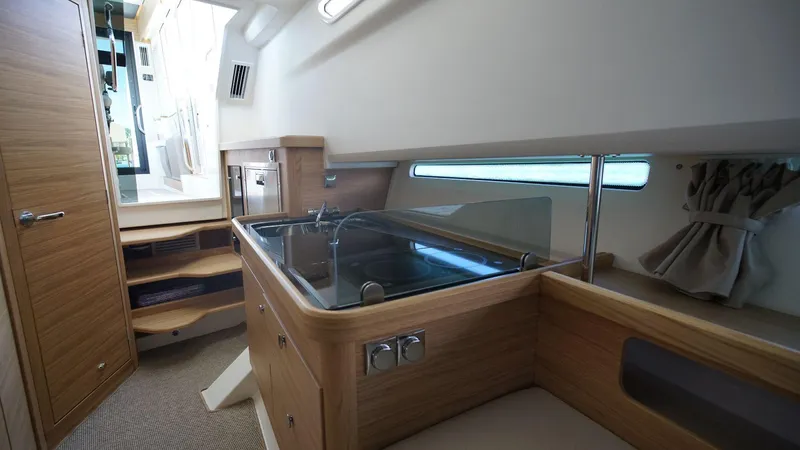 In-stock 2024 Nimbus C11 #082 Yacht Photos Pics Modern kitchen area inside 2024 Nimbus Commuter 11 #082 boat with wooden cabinetry.