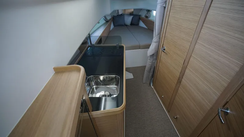 In-stock 2024 Nimbus C11 #082 Yacht Photos Pics 2024 Nimbus Commuter 11 #082 interior with kitchenette and sleeping area.