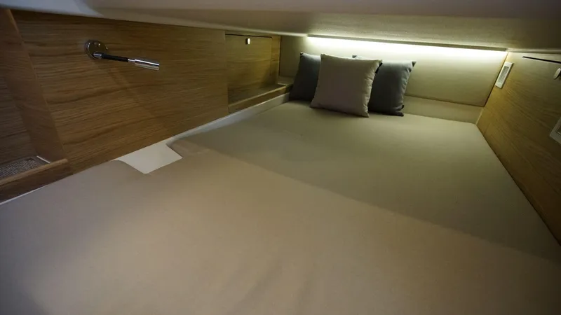 In-stock 2024 Nimbus C11 #082 Yacht Photos Pics 2024 Nimbus Commuter 11 #082 cozy cabin bed with pillows and wooden accents.