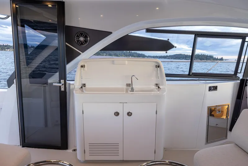 In Stock Yacht Photos Pics 2024 Beneteau Gran Turismo 45 yacht interior with kitchenette and scenic water view.