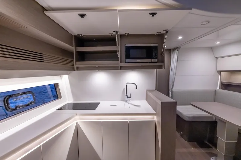 In Stock Yacht Photos Pics Modern kitchen interior of 2024 Beneteau Gran Turismo 45 yacht, featuring sleek cabinetry and appliances.