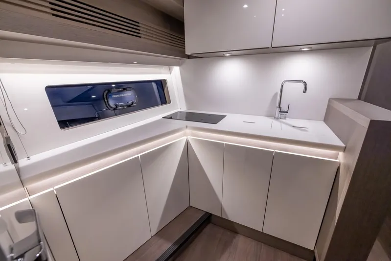 In Stock Yacht Photos Pics Modern kitchen interior of 2024 Beneteau Gran Turismo 45 yacht, featuring sleek cabinetry and fixtures.