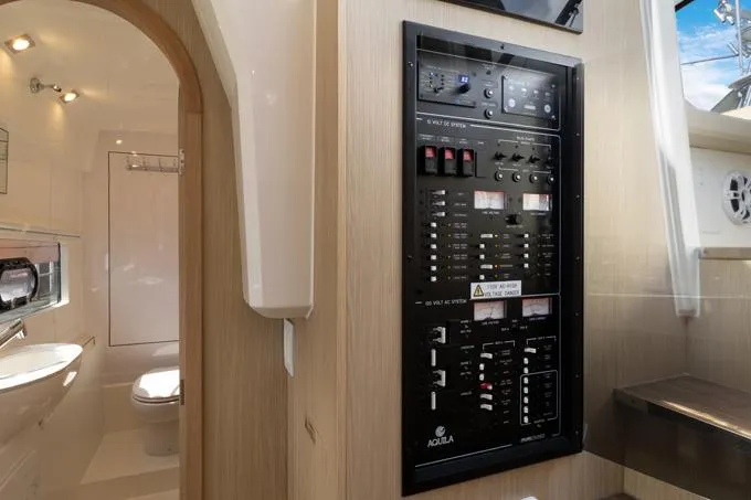 Escape Yacht Photos Pics Electrical panel inside 2022 Aquila 36 Sport yacht, adjacent to modern bathroom.