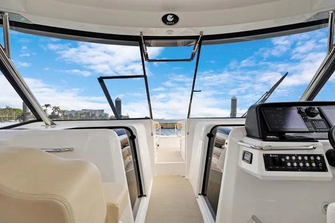 Escape Yacht Photos Pics Interior view of 2022 Aquila 36 Sport yacht with modern dashboard and open sea backdrop.