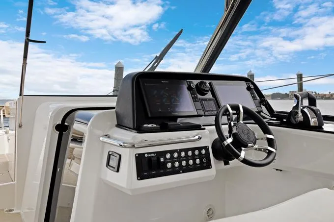 Escape Yacht Photos Pics 2022 Aquila 36 Sport boat dashboard with steering wheel and control panel.