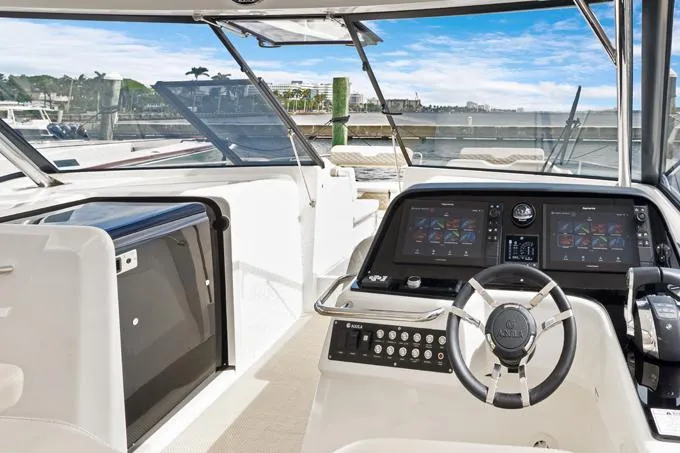 Escape Yacht Photos Pics 2022 Aquila 36 Sport helm with modern controls and navigation screens, docked under clear skies.