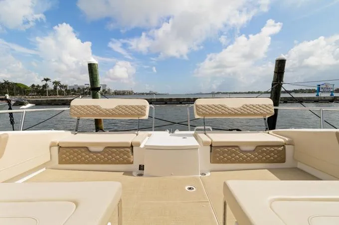 Escape Yacht Photos Pics Aquila 36 Sport 2022 boat deck with beige seating, overlooking a marina.