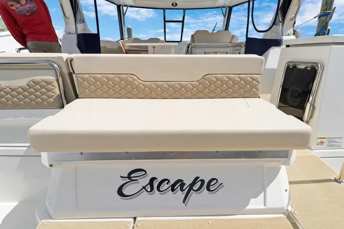 Escape Yacht Photos Pics Aquila 36 Sport 2022 boat with beige seating and "Escape" text on the stern.