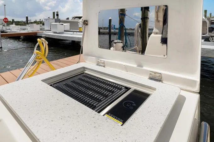 Escape Yacht Photos Pics Outdoor grill on 2022 Aquila 36 Sport boat, docked by the water.