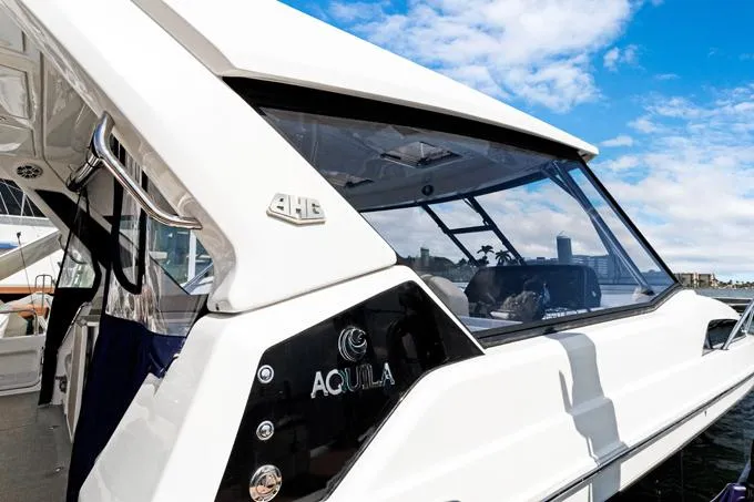 Escape Yacht Photos Pics 2022 Aquila 36 Sport yacht, sleek design, docked under a blue sky.