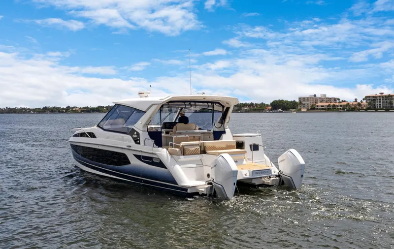 Escape Yacht Photos Pics Aquila 36 Sport 2022 cruising on a calm lake under a partly cloudy sky.