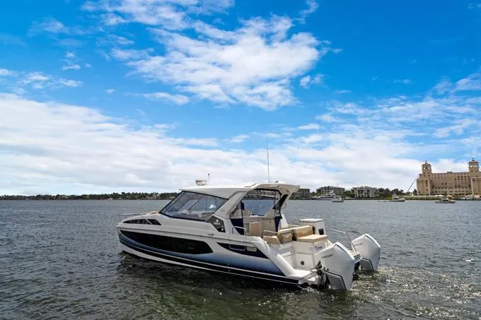 Escape Yacht Photos Pics Aquila 36 Sport 2022 boat cruising on a sunny day with blue sky and waterfront buildings.