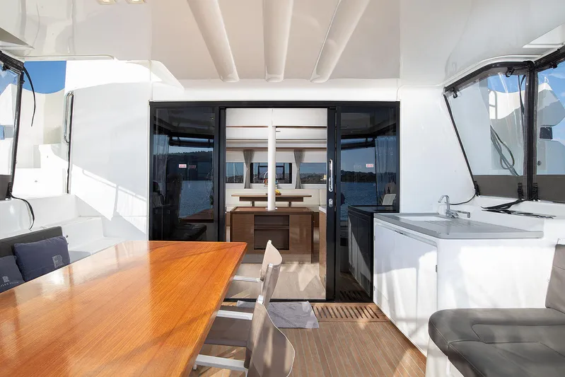  Yacht Photos Pics Interior view of 2022 Lagoon 500 yacht with dining area and kitchenette.