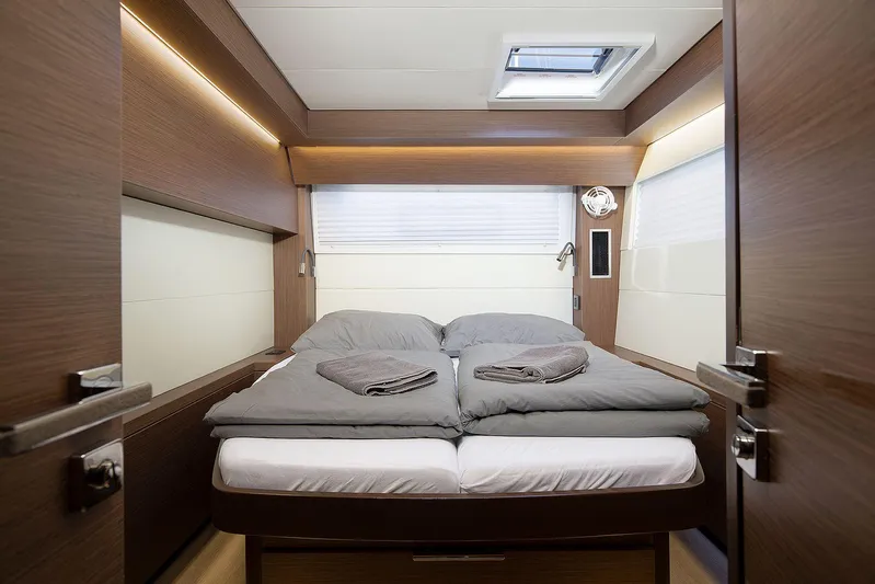  Yacht Photos Pics Luxurious cabin interior of 2022 Lagoon 500 yacht with cozy bedding and modern design.