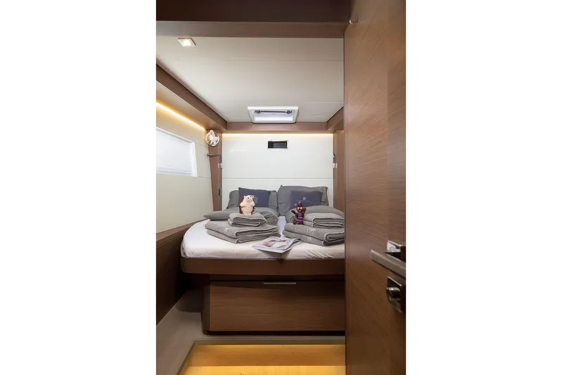  Yacht Photos Pics Luxurious cabin interior of 2022 Lagoon 500 yacht with cozy bedding and ambient lighting.