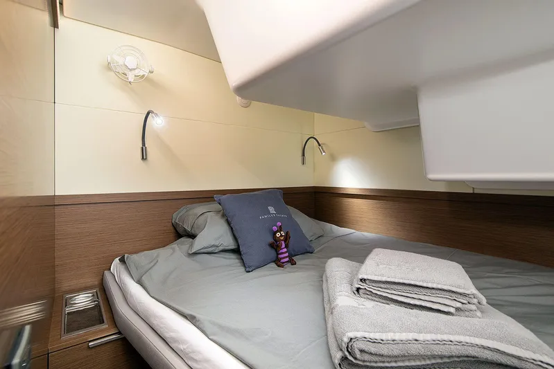  Yacht Photos Pics Cozy cabin interior of 2022 Lagoon 500 yacht with bed, pillows, and reading lights.