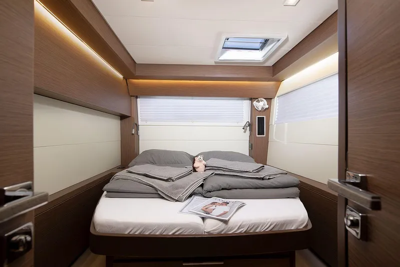  Yacht Photos Pics Luxurious cabin interior of 2022 Lagoon 500 yacht with cozy bedding and modern design.