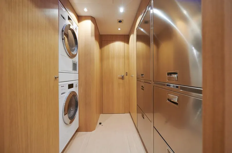 Long Island 78 Yacht Photos Pics Laundry area in 2026 JFA Yachts Long Island 78, featuring modern appliances and wood paneling.