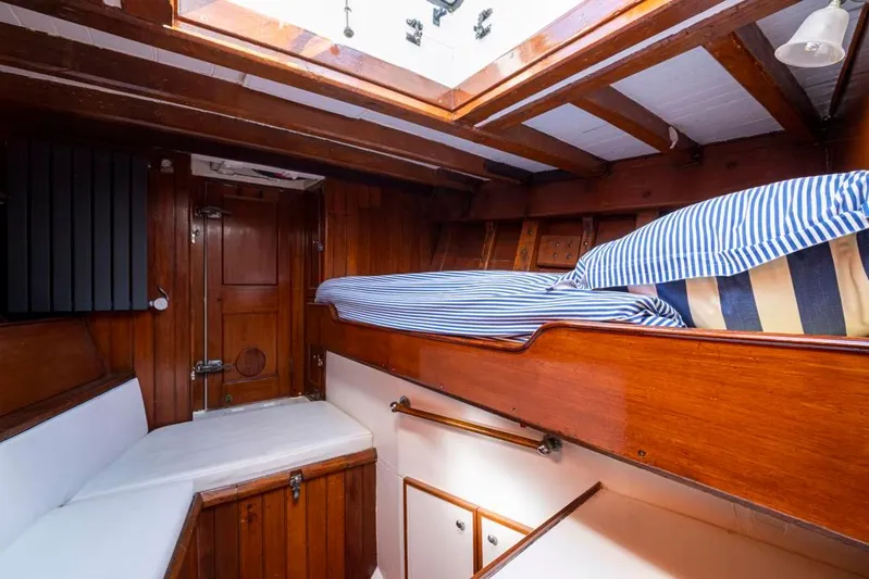 Juliette Yacht Photos Pics 1929 Robertson boat cabin with wooden interior and striped bedding.