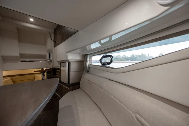  Yacht Photos Pics Interior of 2020 Sea Ray Sundancer 320 Outboard, featuring a cozy seating area and window view.