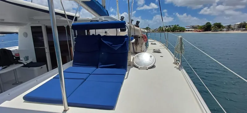  Yacht Photos Pics 2008 Fountaine Pajot Orana 44 Grand Large catamaran with blue deck cushions, docked by a tropical shoreline.