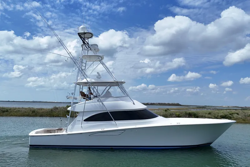 Wildcatter Yacht Photos Pics 2017 Viking 55 Convertible yacht cruising under a blue sky with clouds.