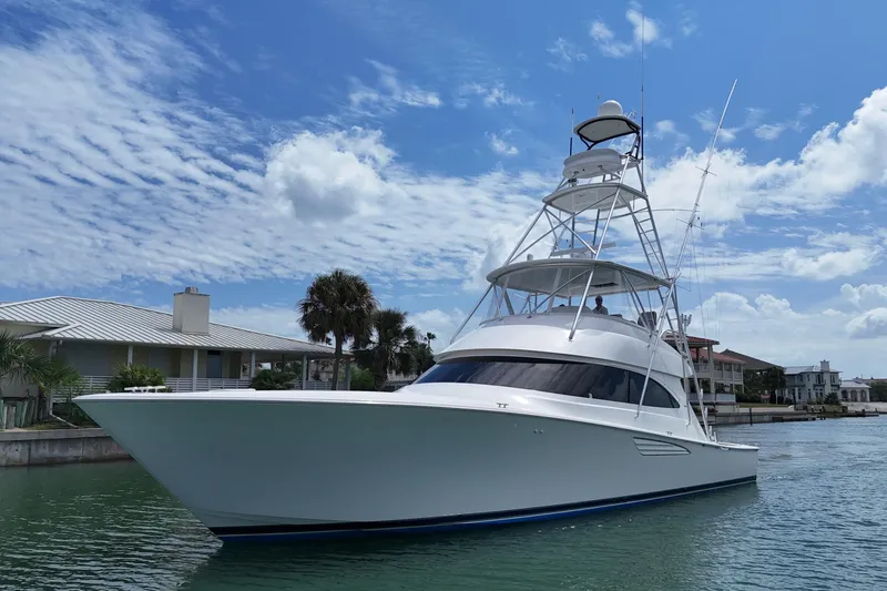 Wildcatter Yacht Photos Pics 2017 Viking 55 Convertible yacht cruising near waterfront homes under a blue sky.