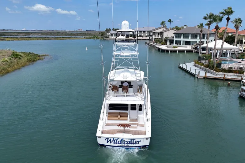 Wildcatter Yacht Photos Pics 2017 Viking 55 Convertible yacht cruising in a scenic waterfront area.