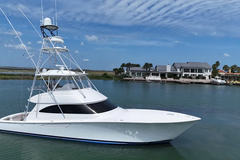 Wildcatter Yacht Photos Pics 2017 Viking 55 Convertible yacht cruising near waterfront homes under a blue sky.
