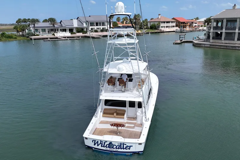 Wildcatter Yacht Photos Pics 2017 Viking 55 Convertible yacht on calm water near waterfront homes.