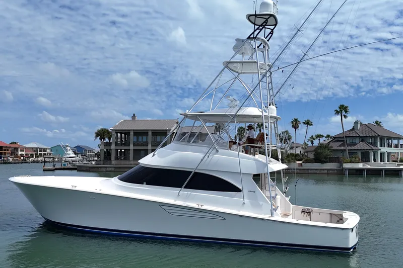 Wildcatter Yacht Photos Pics 2017 Viking 55 Convertible yacht docked near waterfront homes under a blue sky.
