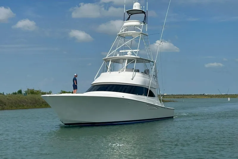 Wildcatter Yacht Photos Pics 2017 Viking 55 Convertible yacht cruising on a calm waterway under a clear sky.