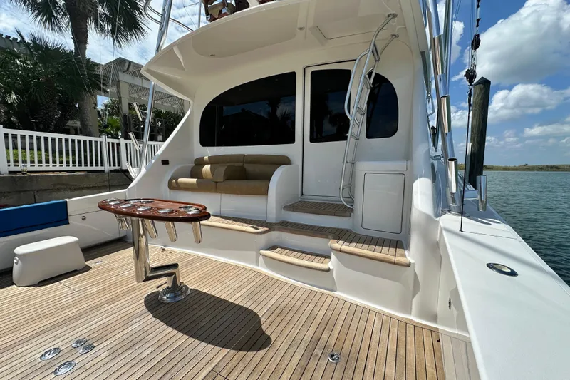 Wildcatter Yacht Photos Pics 2017 Viking 55 Convertible yacht with teak deck and seating area, docked by water.