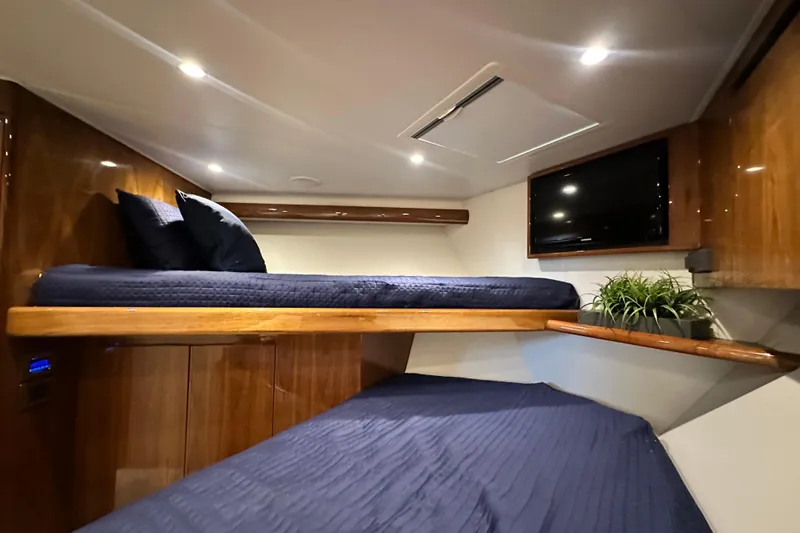 Wildcatter Yacht Photos Pics Luxurious cabin interior of 2017 Viking 55 Convertible yacht with cozy bedding and TV.