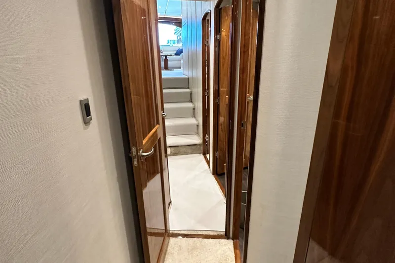 Wildcatter Yacht Photos Pics Hallway inside 2017 Viking 55 Convertible yacht with wooden doors and carpeted stairs.