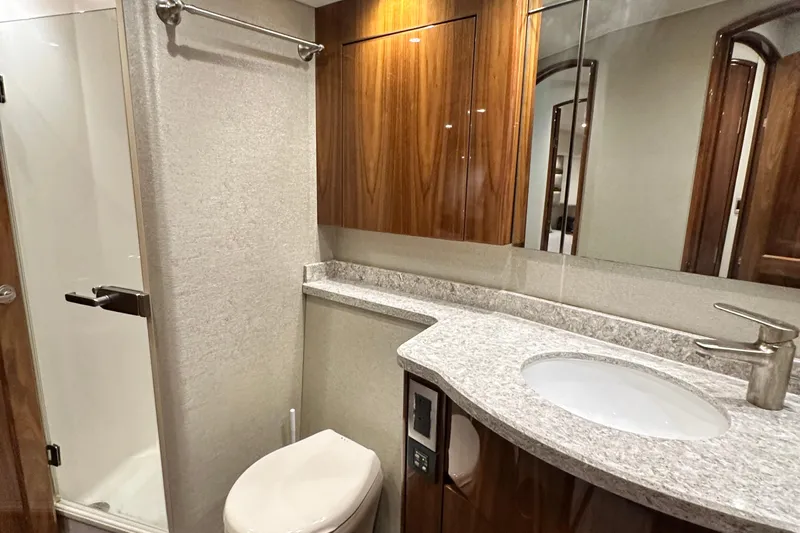 Wildcatter Yacht Photos Pics Luxurious bathroom in 2017 Viking 55 Convertible yacht with modern fixtures and wood accents.