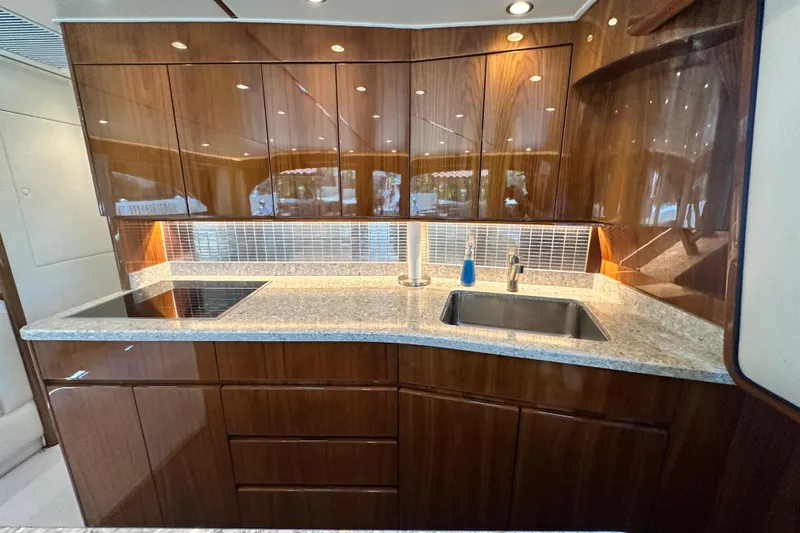 Wildcatter Yacht Photos Pics Luxurious kitchen in 2017 Viking 55 Convertible yacht with sleek wood cabinetry and modern fixtures.