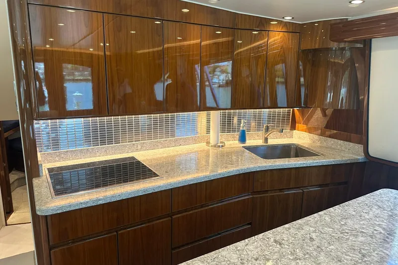 Wildcatter Yacht Photos Pics Luxurious kitchen interior of 2017 Viking 55 Convertible yacht with sleek wood cabinetry.