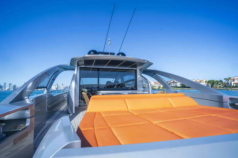 M Yacht Photos Pics 2018 Pershing 70 yacht with orange seating, sleek design, and city skyline in the background.